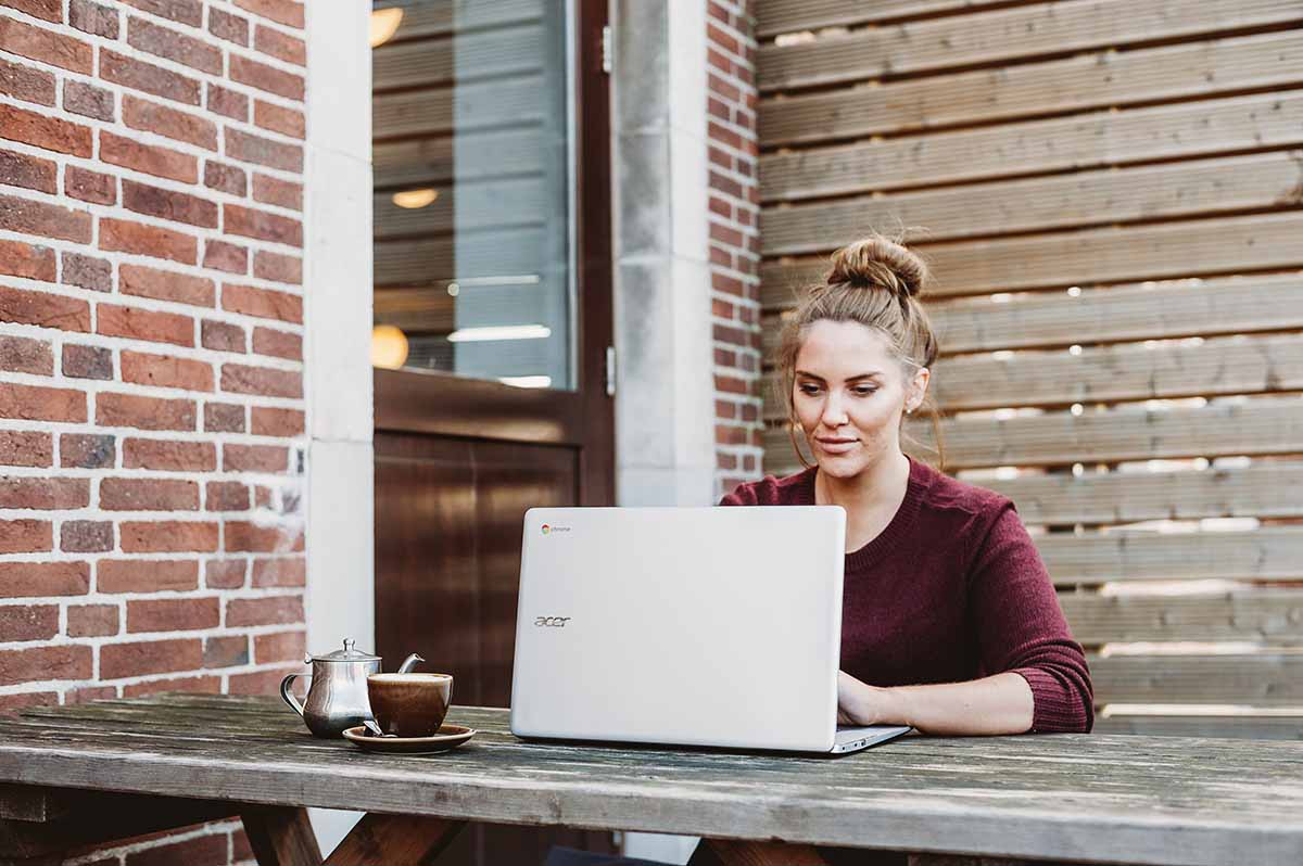 Woman working on laptop at picnic table