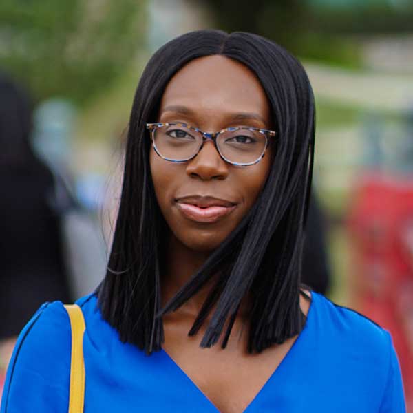 African American Female in blue dress wearing glasses